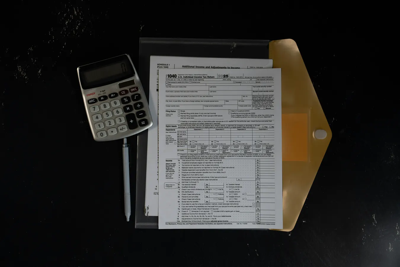 Documents et calculatrice sur un bureau, utilisés pour préparer une analyse